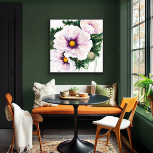 A square canvas wall art print featuring large light pink and white flowers with green leaves and yellow centers, displayed above an orange upholstered bench in a styled dining room with dark green walls and wooden chairs.