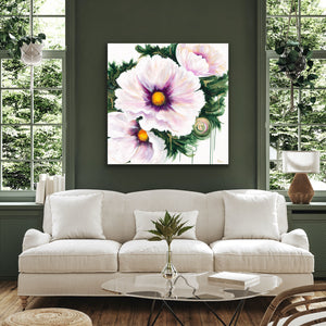 A square canvas wall art print featuring large pale pink peony flowers with green leaves and yellow centers, displayed above a white sofa in a modern living room with dark green walls and tall windows.