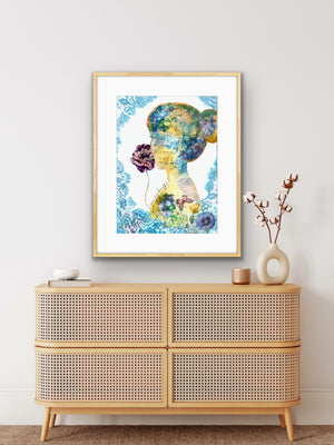 Framed abstract artwork above a rattan cabinet with decorative items.