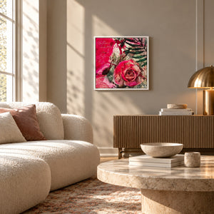 A framed pink floral wall art print featuring a pink rose and green leaves, displayed in a modern living room setting above a wooden console table.