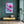 Luxury magnolia canvas print with pink flowers displayed on a deep green wall above a modern bench with a plant in a stylish interior