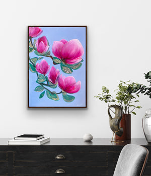 Luxury magnolia framed canvas print with soft pink flowers displayed in an elegant living room interior with feminine, calming atmosphere