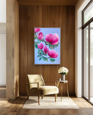Luxury magnolia canvas print with soft pink flowers displayed in a warm wooden interior with a chair and natural light, elegant feminine wall art