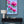 Luxury magnolia canvas print with soft pink flowers displayed on a blue wall above a console table in an elegant, feminine interior